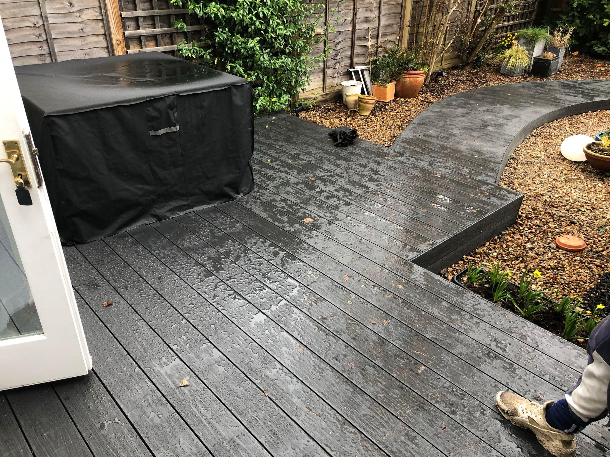 Dark composite decking with curved gravel garden path, Surrey
