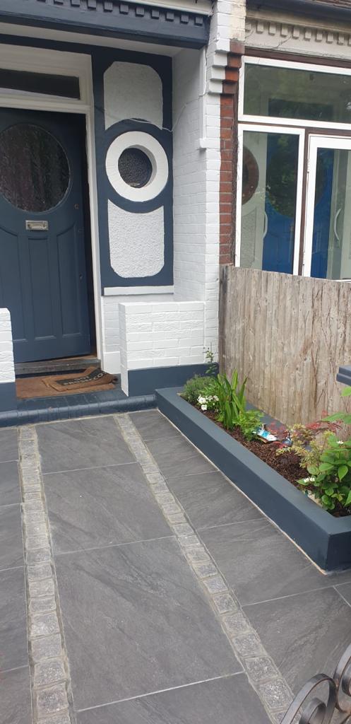 Dark grey porcelain front garden path with raised planter and blue door, Surrey