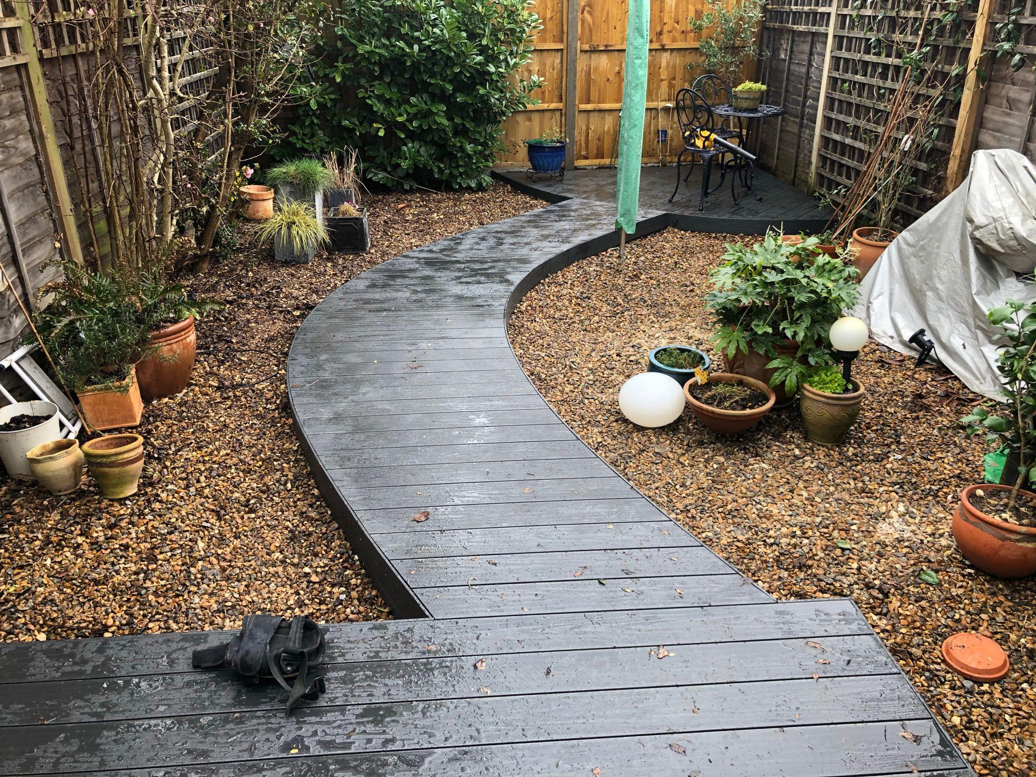 Dark timber curved garden path through gravel courtyard, Surrey