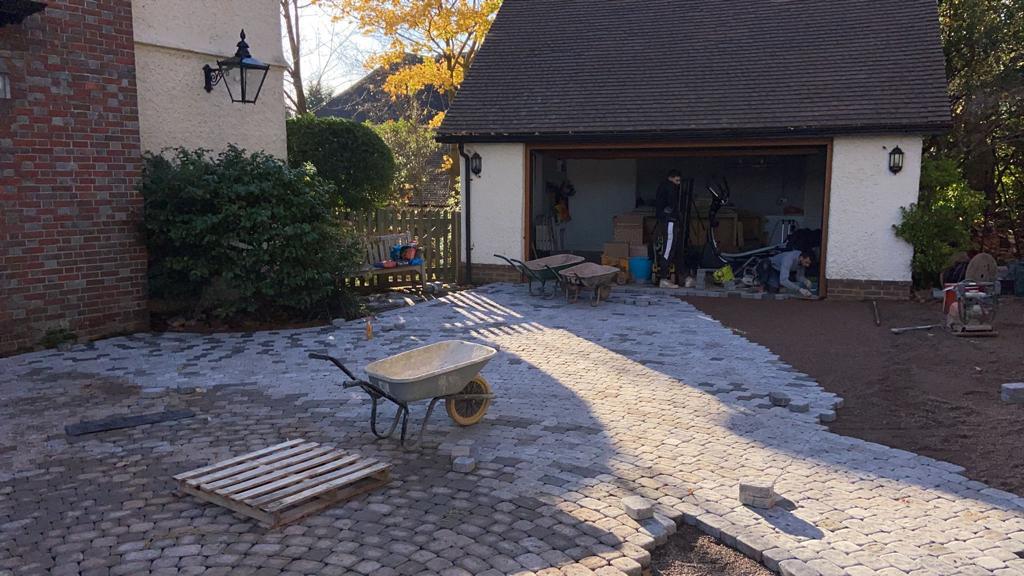 Granite sett driveway installation in progress at detached house, Surrey