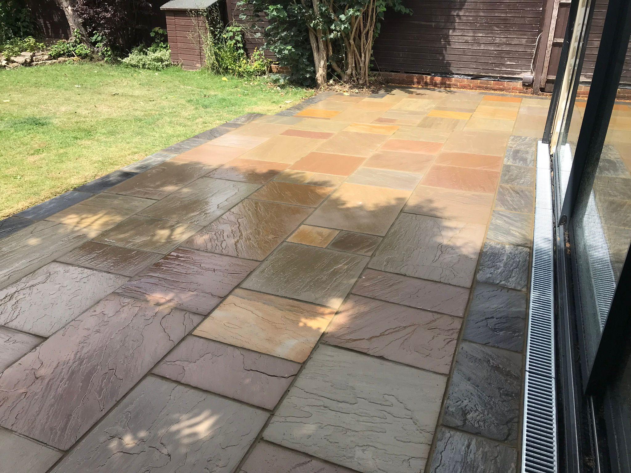Indian sandstone patio with channel drain in rear garden, Surrey