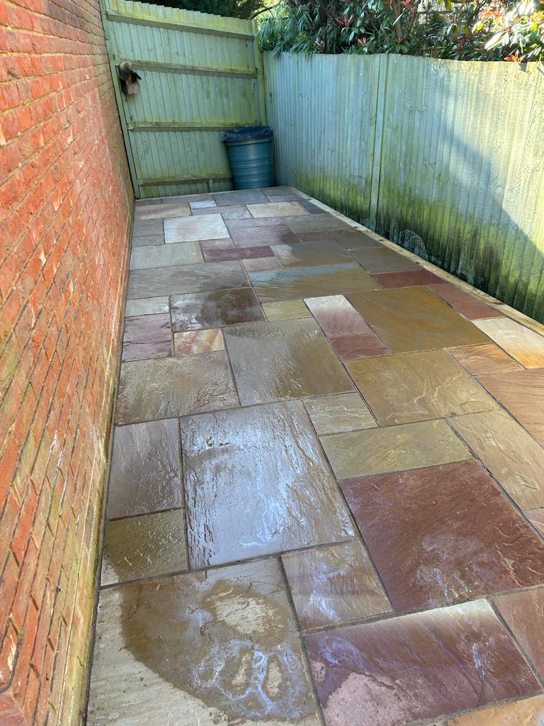 Indian sandstone side return patio with brick wall and timber fence, Surrey