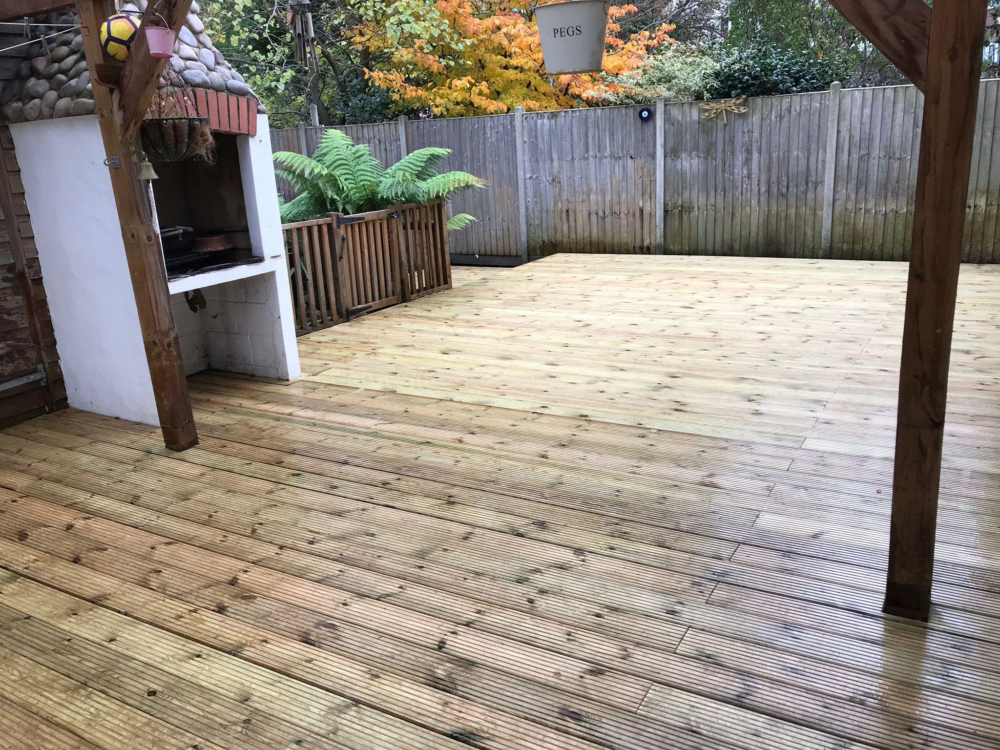 Large timber decking with BBQ area and close-board fencing, Surrey