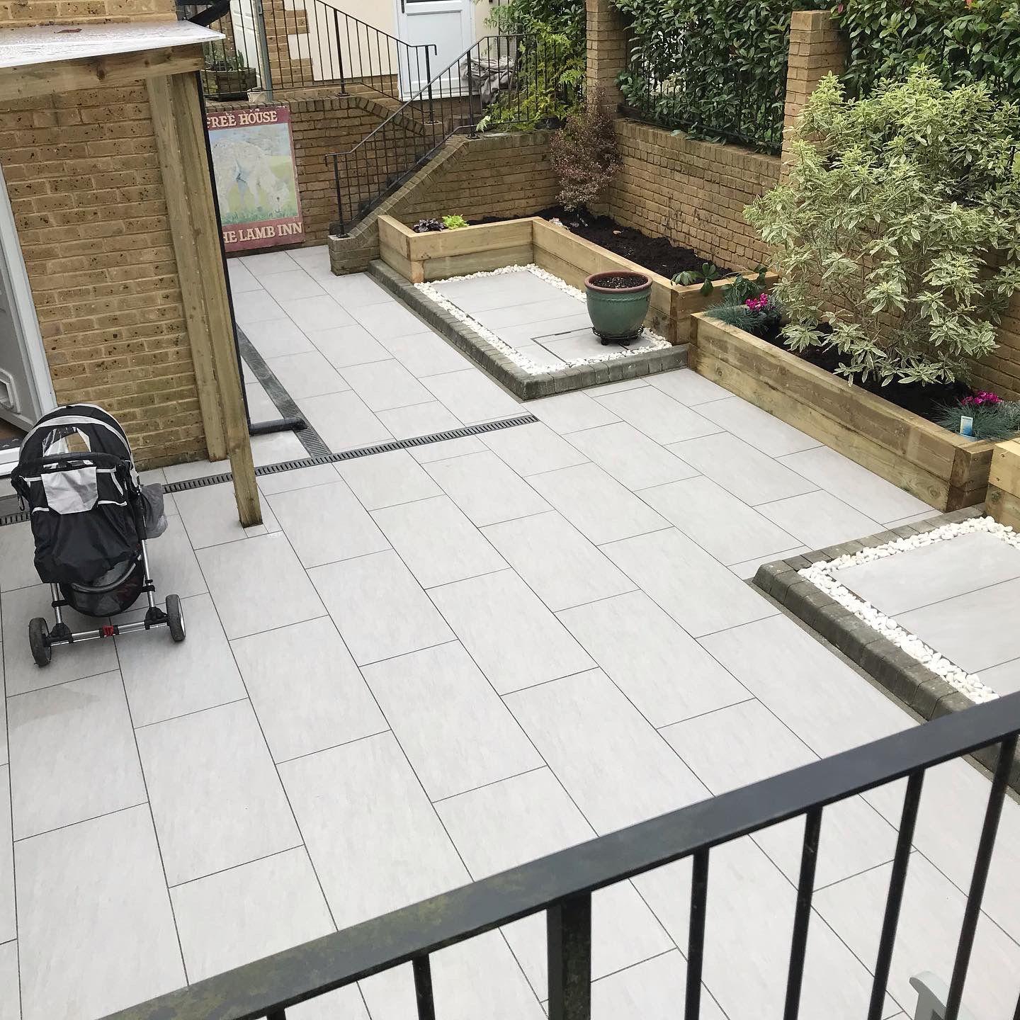 Porcelain patio with raised sleeper planters and gravel, Surrey