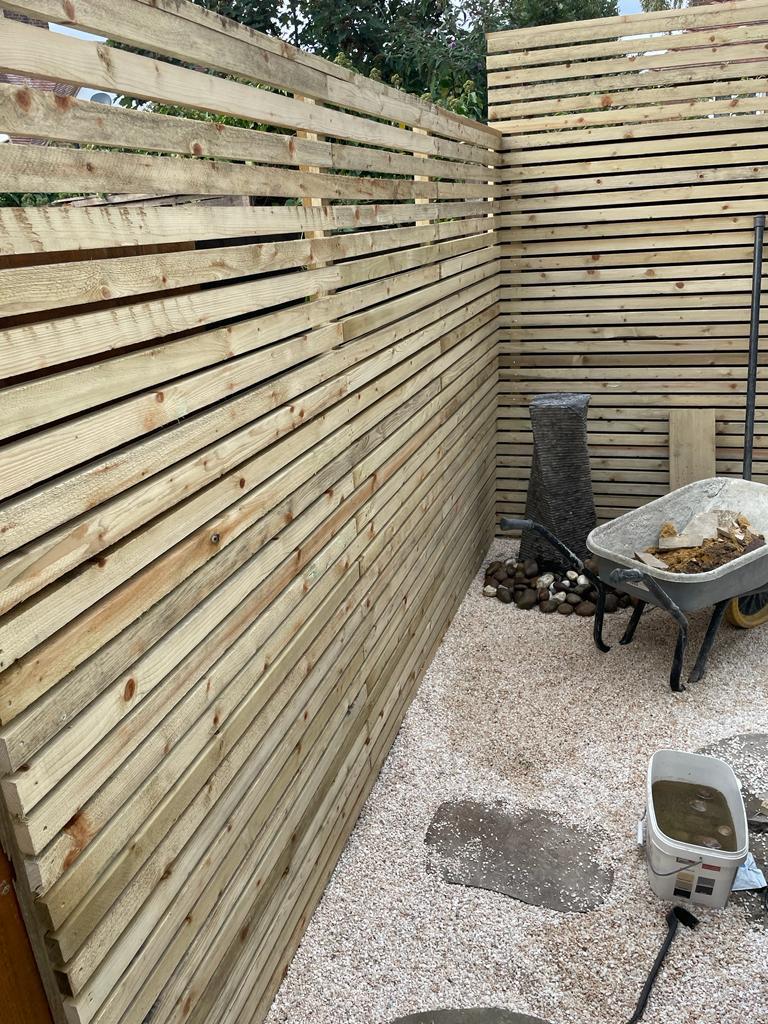 Slatted timber horizontal fence panel with gravel courtyard, Surrey