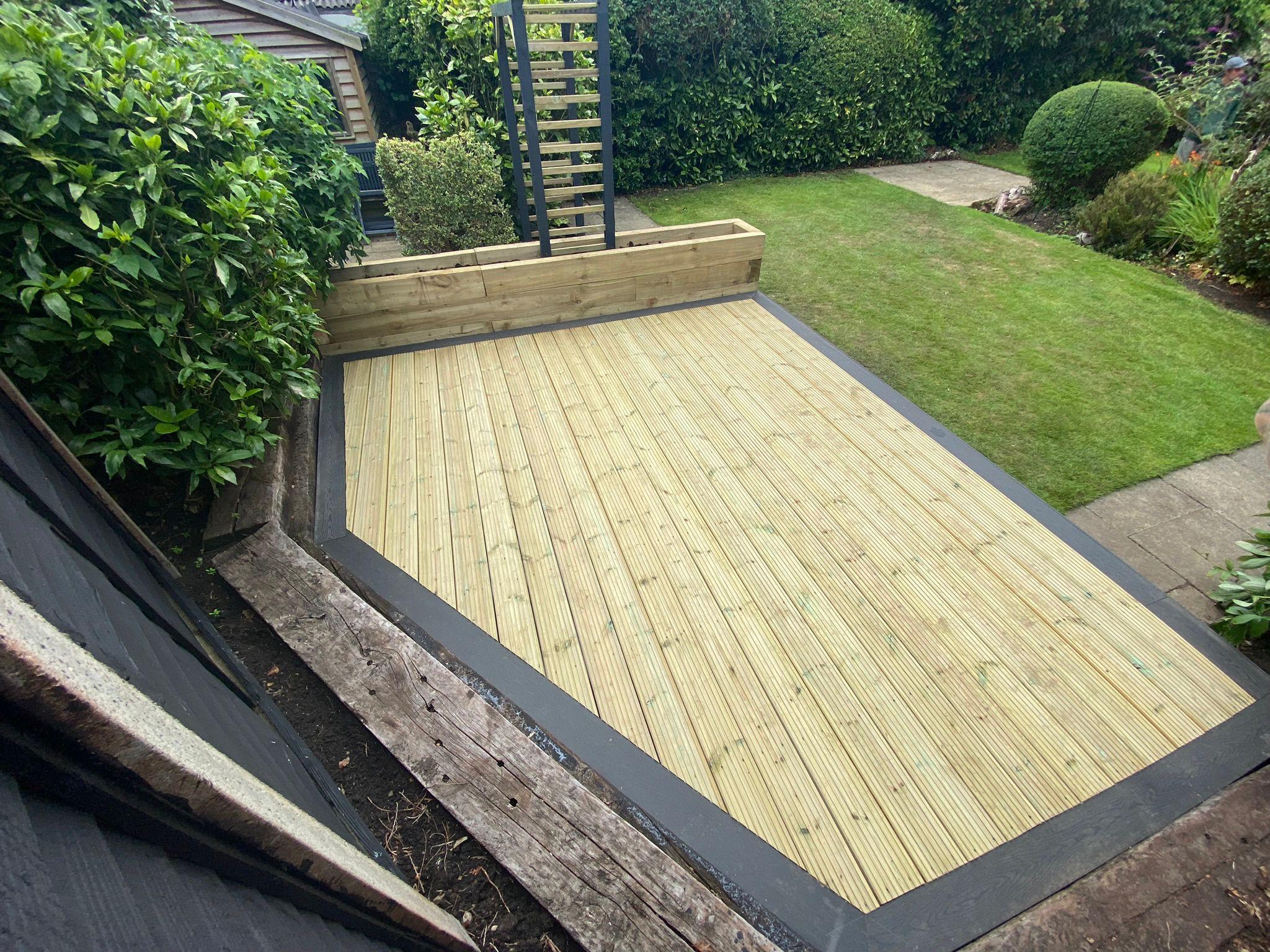 Timber decking with composite border, raised planter and lawn, Surrey