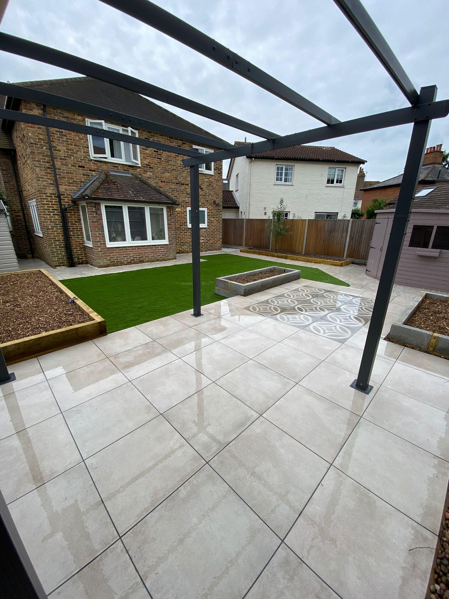White porcelain patio with pergola, artificial grass and decorative mosaic, Surrey