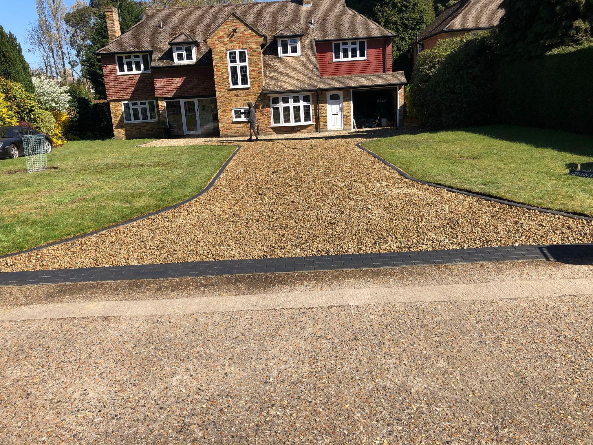 Wide gravel driveway with curved edging at detached house, Surrey